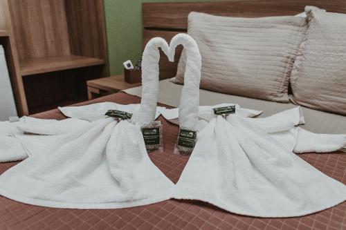 two white towels sitting on top of a bed at Pousada Valle Verde in Cabo Frio