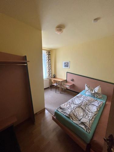 ein Schlafzimmer mit einem Bett und einem Schreibtisch. in der Unterkunft Pension Sachsens Einkehr in Leipzig