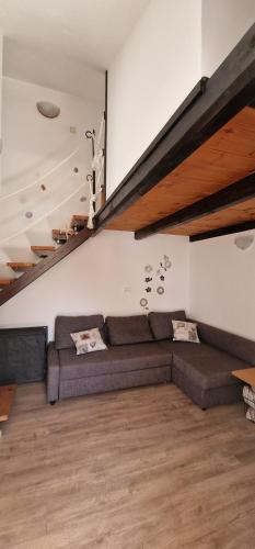 a living room with a couch and a staircase at Apartmani Dutković in Vrboska