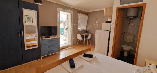 a kitchen and living room with a refrigerator and a table at Apartmani Dutković in Vrboska