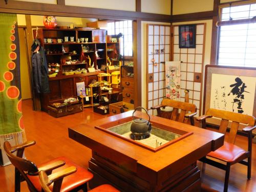 a living room with a wooden table and chairs at Super Hydrogen Rich Spa Yado Kanzan in Minakami