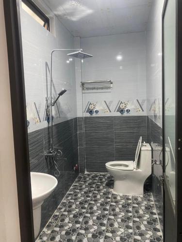 a bathroom with a toilet and a sink at Nhà nghỉ Hoàng Gia in Ba Tơ