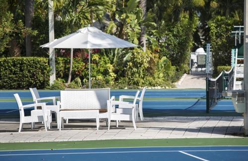 a table and chairs with an umbrella on a tennis court at Cheeca Lodge & Spa in Islamorada