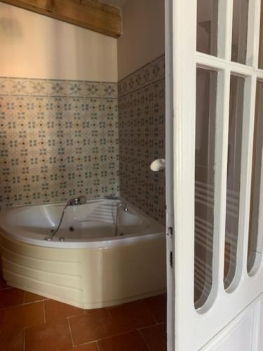a bathroom with a bath tub in a room at Buisson gîte et chambre d'hôte in Laruscade