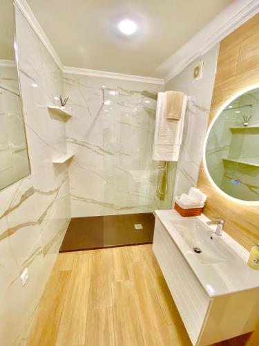 a white bathroom with a sink and a mirror at A Casa dos Sonhos in Chaves