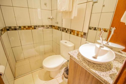 a bathroom with a toilet and a sink at TaguaPark Hotel in Taguatinga