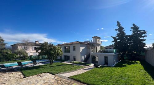 a large white house with a grass yard at Villa Constance - Antibes in Antibes