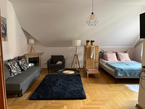 een woonkamer met een bank en een bed bij Apartament pod Dębami in Polanica-Zdrój