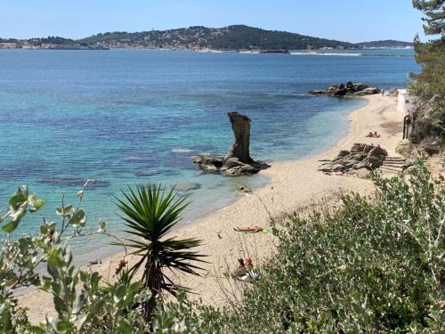 a beach with people laying on the sand and the water at Superbe appartement à 5 minutes à pied de la mer in Toulon