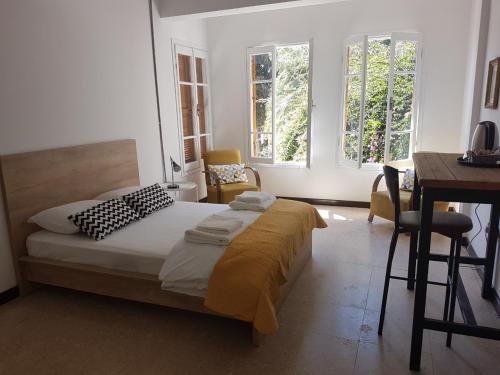 a bedroom with a bed and a desk and two windows at Sabor Residence in North Nicosia