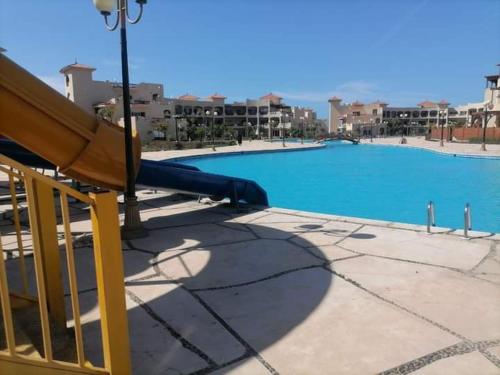 a swimming pool with a slide in front of a building at طريق الساحلي الدولي بلطيم in Al Ḩammād