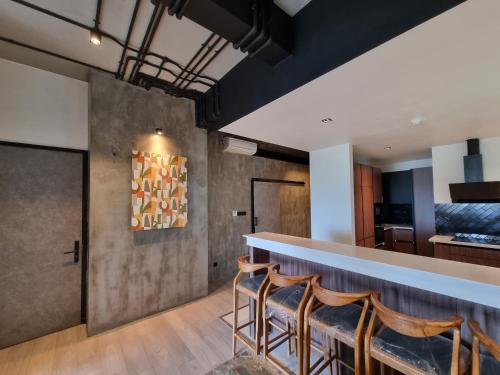 a bar in a room with chairs and a counter at VAUX Park Street Hotel - A collection of 8 luxury lofts in Colombo