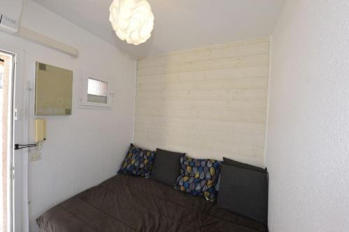 een slaapkamer met een bed in een kamer met een licht bij Joli studio à 5min de la plage à Palavas in Palavas-les-Flots