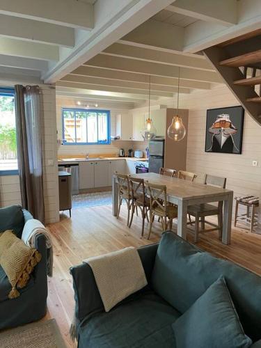 - un salon avec un canapé et une table à manger dans l'établissement La maison aux Volets Bleus - Plage des Américains, à Lège-Cap-Ferret