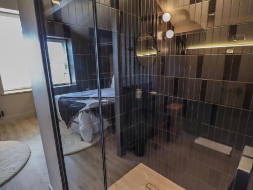 una ducha con puerta de cristal en una habitación en Glencoe House, en Wooler