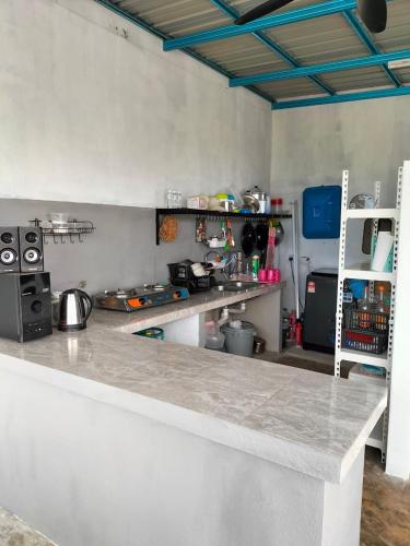a kitchen with a counter and a counter top at De Hampar Homestay in Kampong Merbok