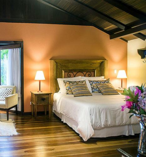 a bedroom with a large bed and a chair at Maua Brasil Hotelaria in Visconde De Maua