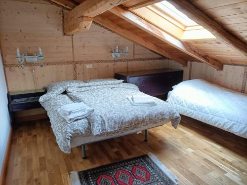 a bedroom with two beds in a attic at La ciasa dei senteri in Ronzone