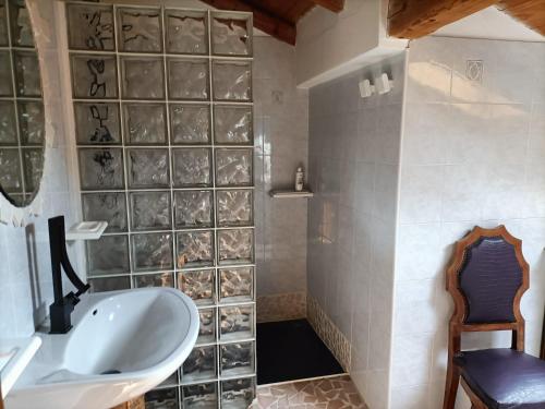 y baño con bañera, lavamanos y silla. en Resort CuraLibera en Ronzone