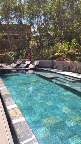 a swimming pool with blue water in a yard at Relais De Mantadia in Andasibe