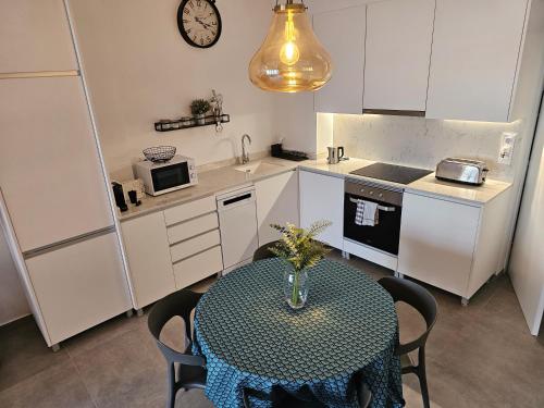 una pequeña cocina con una mesa y un reloj en la pared en Jardín Viveros-Turia 6 PAX-WIFI Y PARKING GRATIS en Valencia