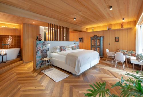 a bedroom with a large bed and a bathroom at MalisGarten Green Spa Hotel - Adults Only in Zell am Ziller