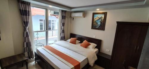 een slaapkamer met een bed en een groot raam bij Hotel Pipal Tree in Kathmandu