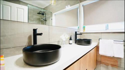 uma casa de banho com um grande lavatório preto num balcão em Home in Sunshine North em Albion