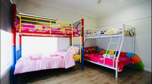 a bedroom with two bunk beds and a ladder at Home in Sunshine North in Albion