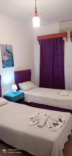 een kamer met 2 bedden en een paars gordijn bij Şahin Otel in Bodrum City