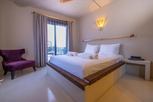 sypialnia z dużym łóżkiem i fioletowym krzesłem w obiekcie Void Hotel Urla w mieście Urla