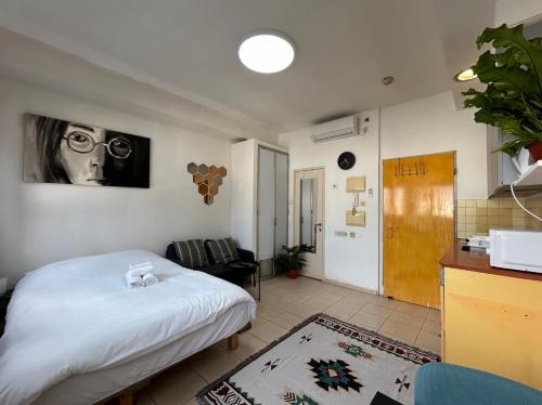 a bedroom with a bed and a kitchen with a sink at Lev Florentin Apartments - Montefiore TLV in Tel Aviv