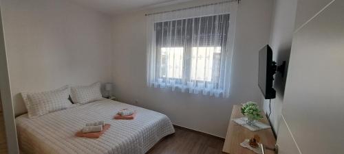 a small bedroom with a bed and a window at Apartman La-iv in Bjelovar