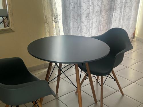 a table and two chairs in front of a window at Phindulo Bed and Breakfast - No Loadshedding, Smart TVs & unlimited free fibre wifi in Krugersdorp