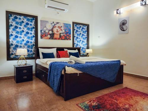 a bedroom with a bed with blue and red pillows at Beach Villa Morjim in Morjim