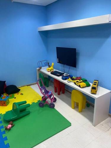 a room with a desk with a television and toys at Vista Espetacular Porto Real suítes in Mangaratiba