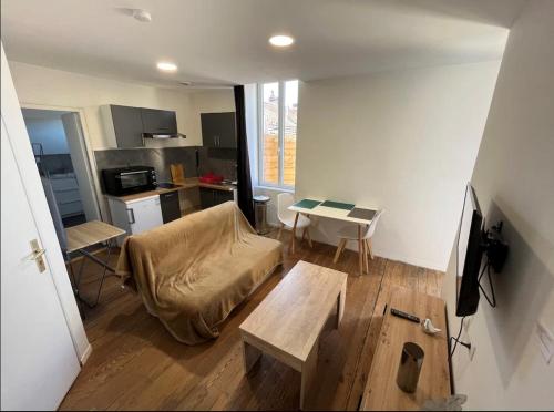 un salon avec un canapé et une table dans l'établissement Charmant appartement avec terrasse proche du centre, à Périgueux