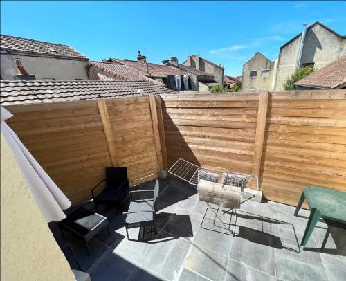 une terrasse avec une clôture, une table et des chaises dans l'établissement Charmant appartement avec terrasse proche du centre, à Périgueux