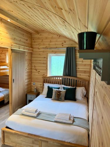 a bedroom with a bed in a log cabin at Dwell on the Moor in Holme upon Spalding Moor