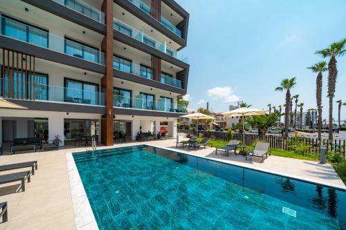 a swimming pool in front of a building at Waterside Sea View Apartments in Paphos
