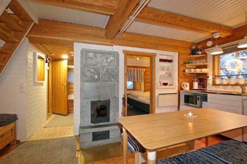 a kitchen and dining room with a fireplace in a tiny house at Saremökki in Kittilä