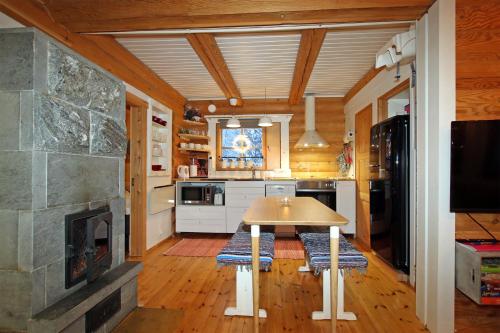 a kitchen with a table and a fireplace at Saremökki in Kittilä