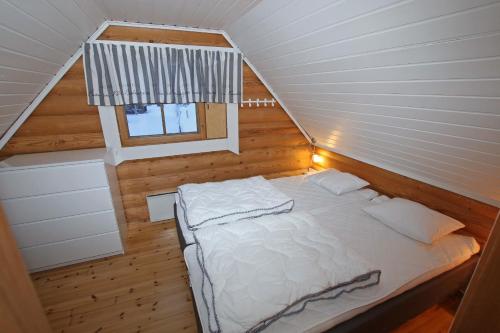 a bedroom with a white bed in a attic at Saremökki in Kittilä
