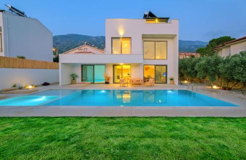a villa with a swimming pool in front of a house at Villa Neo with 2 private pools, bbq, jacuzzi and sauna in Fethiye