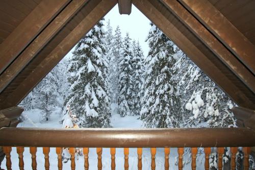 a window in a cabin with snow covered trees at Saremökki in Kittilä