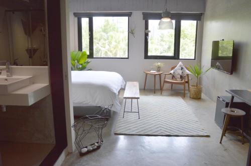 a bedroom with a bed and a sink and a bathroom at Tomato TTT 番茄行旅 in Taipei