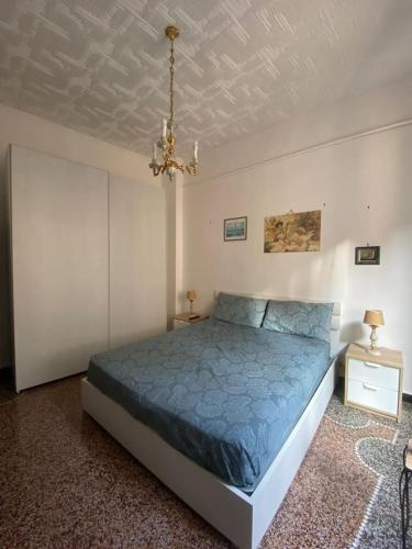 a bedroom with a blue bed and a chandelier at La Palma di Rafé in Genova