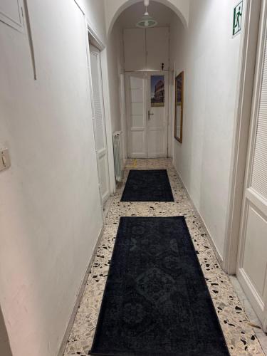 a hallway with two black rugs on the floor at Baraka Guest House in Rome