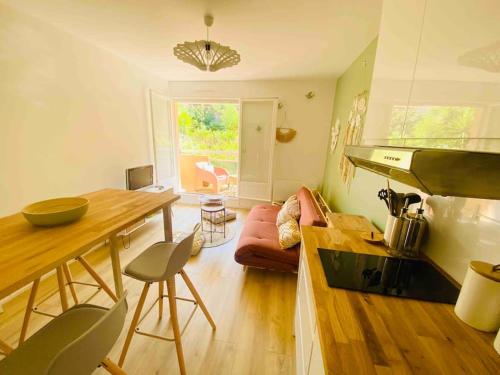 une cuisine et un salon avec un canapé et une table dans l'établissement Appartement à la Favière T2 à 5 minutes à pied de la plage, à Bormes-les-Mimosas