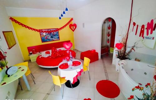 a room with a table and a bathtub and a table and chairs at La Baia Di Ulisse in Venetico